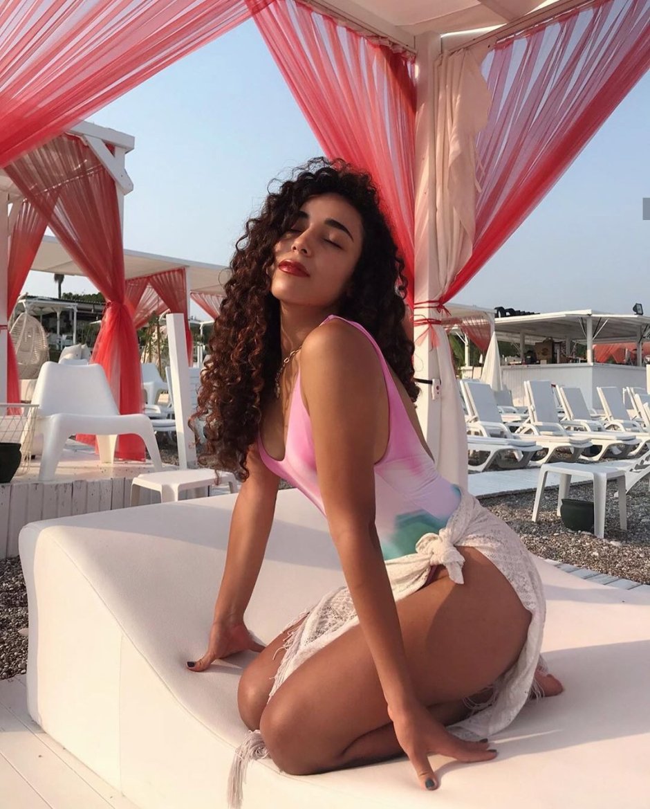 Girl on the beach in a swimsuit with a cocktail