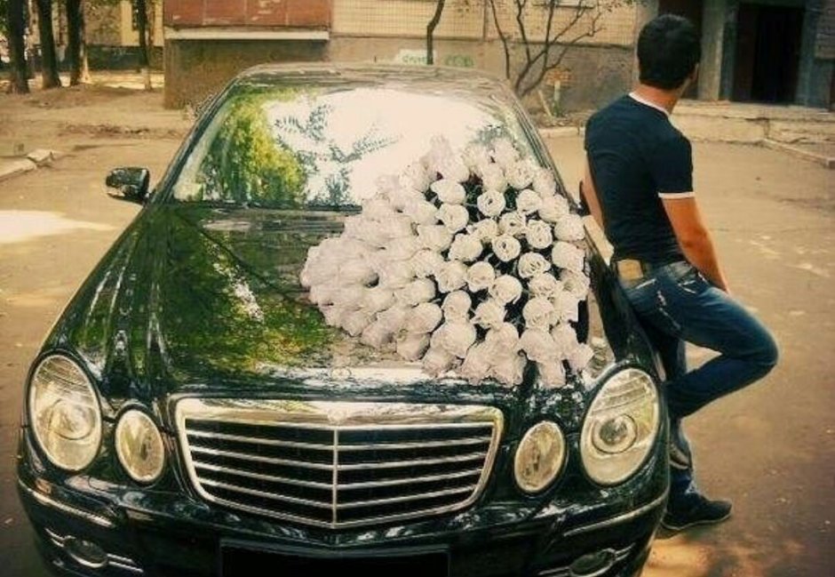 Man with flowers near the car